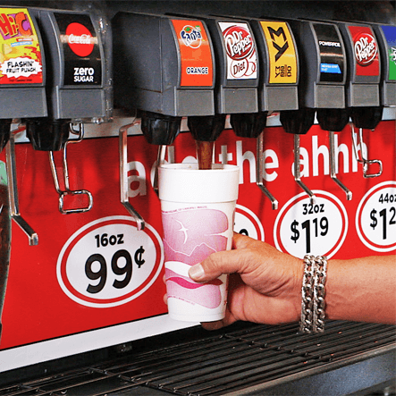 Hand holding a free 20 oz fountain drink from our Friday Fill-Ups promotion